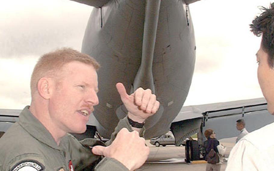 Master Sgt. Steve (Opie) Flax, a KC-135 boom operator, explains to a Japanese journalist how aircraft hook up to the refueling boom of a KC-135 tanker.