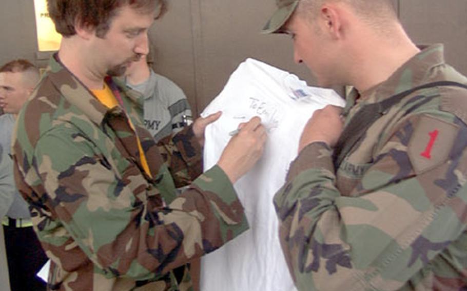 Comedian Tom Green signs an autograph for a 1st Infantry Division soldier at Camp Bondsteel, Kosovo, on Friday. Geen, known for his antics on his own MTV show, is on a weeklong tour of the Balkans through the United Service Organizations.