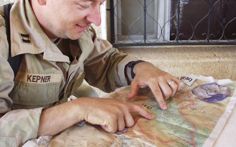 Army Capt. Mike Kepner, commander for V Corps headquarters and headquarters company, shows on a map the route he and his staff took as they kept supplied and moved the forward headquarters element of V Corp in the fighting across Iraq.