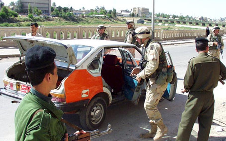 Troops from 2nd Battalion, 503rd Infantry Regiment, out of Vicenza, Italy, and local police officers conduct a spot-traffic stop in Kirkuk, looking for contraband such as weapons and ammunition.
