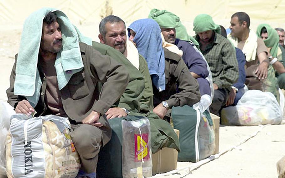 Former Iraqi prisoners wait for a ride home Tuesday at Camp Bucca