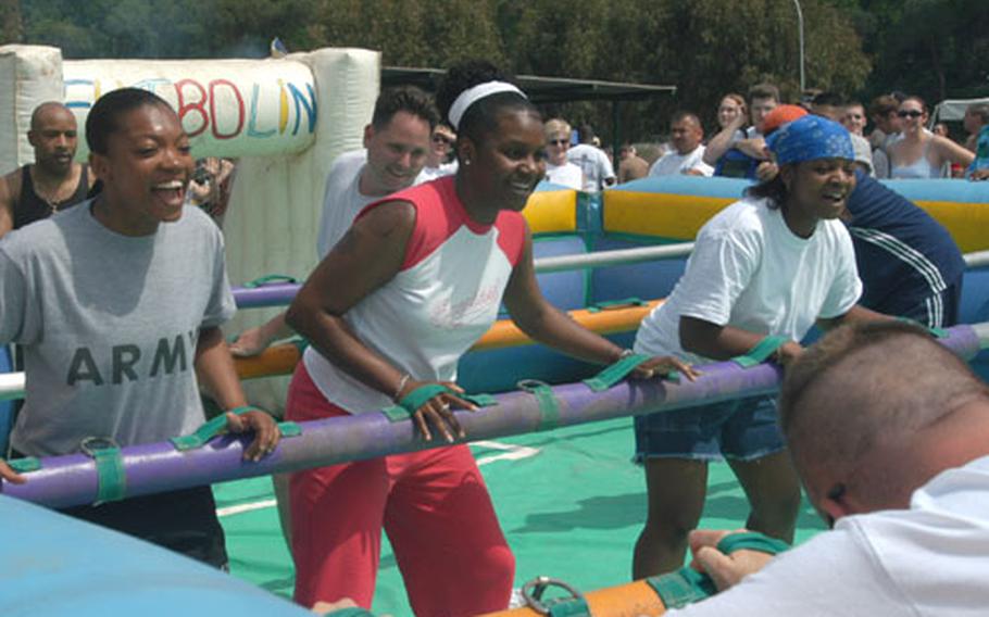 The human foosball competition drew lots of laughs Friday at the Armed Forces Olympics at Carney Park in Naples, Italy. Playing from left were Army Sgt. Shonda Haddock, 27, from Greeneville, N.C.; Air Force Staff Sgt. Sabrina Crawford, 28, from Charlotte, N.C.; and Navy Petty Officer 2nd Class Janina McQueen, 24, from Greensboro, N.C.