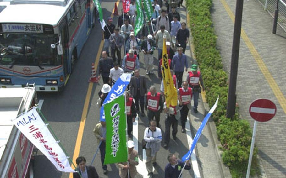 Japanese protesters march toward the front gate of Yokosuka Naval Base on Saturday.