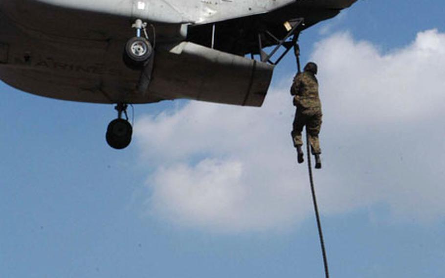 A U.S. Marine rappels 70 feet from a CH-46 as part of a fast rope jump during Balikatan 2003 at Clark Air Base, Philippines.