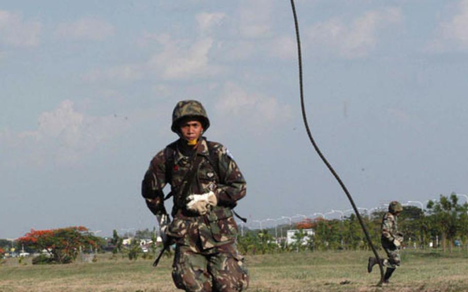 Philippine servicemembers hit the ground running after a 70-foot rappel from a U.S. Marine CH-46.