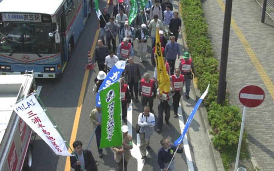 Protesters march toward the front gate of Yokosuka Naval Base on Saturday.