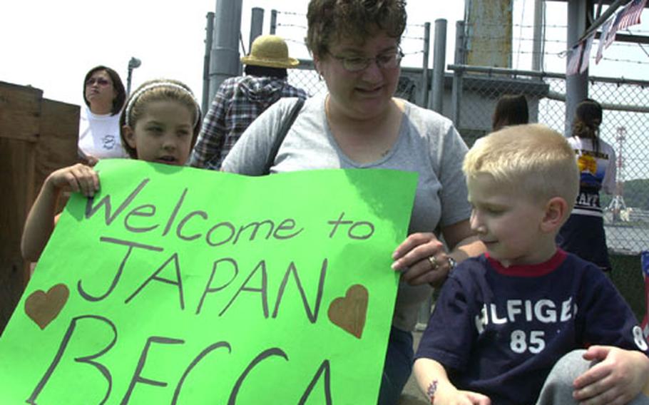 Niki Ruscitto reunited with her sister, Airman Rebecca Sullins from the USS Carl Vinson’s air division, after the Vinson anchored in Yokosuka on Saturday. Before Sullins stepped ashore from a liberty boat, Ruscitto waited with her daughter, Jamie, and son, Clayton, proudly displaying their bright green poster welcoming Sullins to Japan.