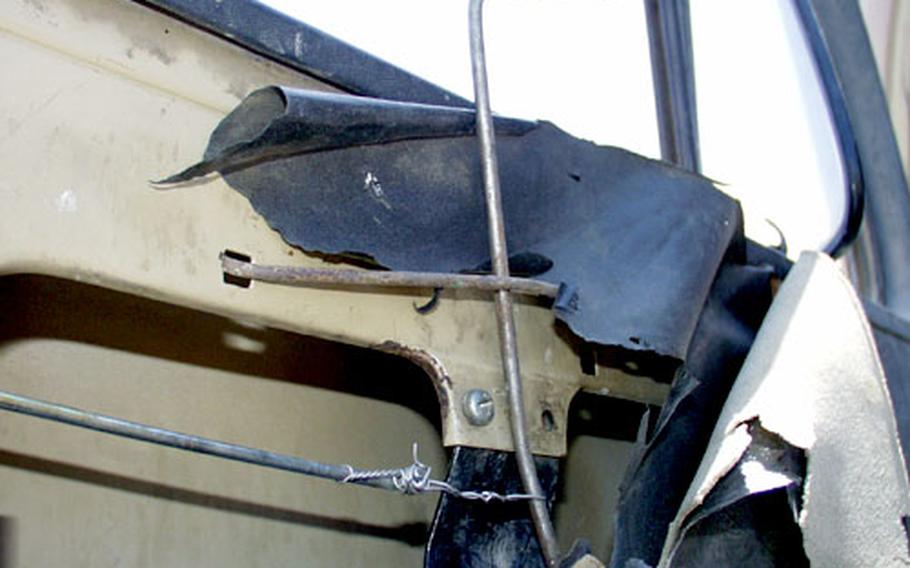 Air Force mechanics used wire and steel cables to rig a door handle on this old Iraqi truck.