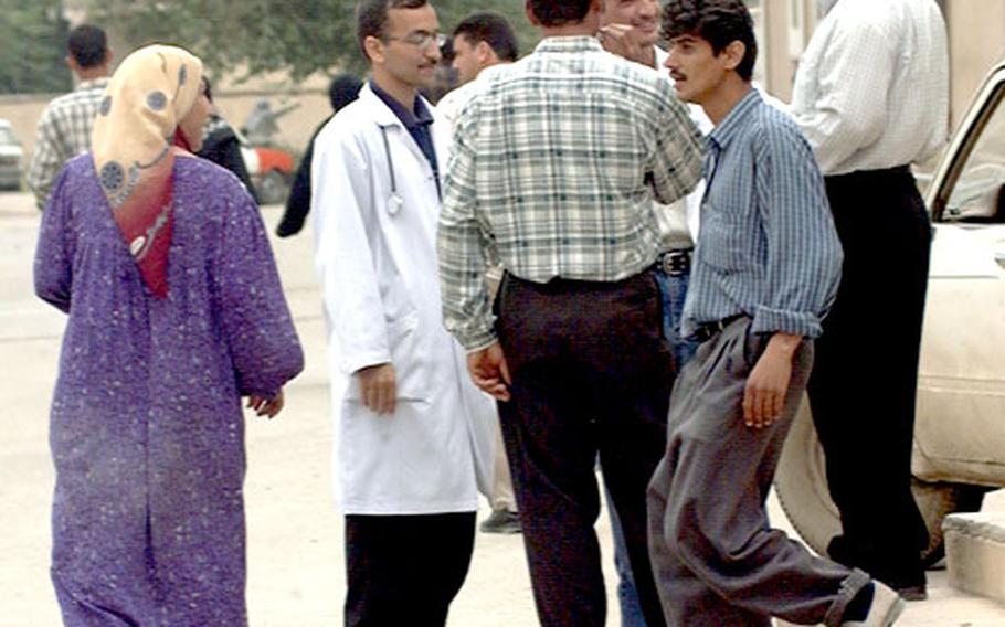 A doctor mingles with patients and staff outside Kirkuk General Hospital in Kirkuk, Iraq. The 400-bed hospital must defer non-life-threatening procedures in order to make their medical supplies last until the international community arrives on their doorstep with aid.