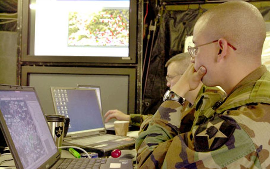 Sgt. Robert Gray (front) and 1st Lt. Stephen Sams work in the effects cell of the division headquarters Sunday during the Warfighter exercise, which tests the command and control of the division during a computer simulated war game.