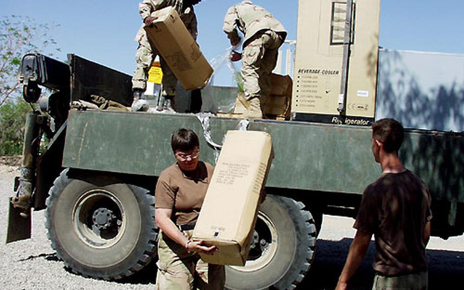 Cynthia Grzybowski, manager of the new AAFES store at Victory Camp in Baghdad, Iraq, helps unload merchandise.