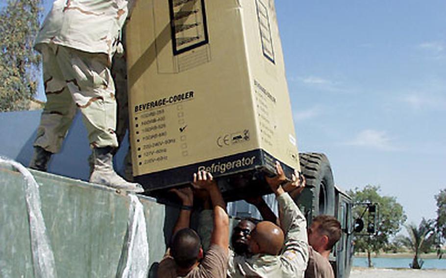 Army and Air Force troops unload a new refrigerator at the Army and Air Force Exchange Service store, set to open Friday at Victory Camp in Baghdad.