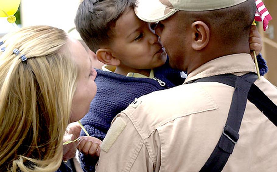 Domenic Espinoza, 2½, gives his dad, Chief Warrant Officer 2 Michael Espinoza, a kiss as mom Anja watches.