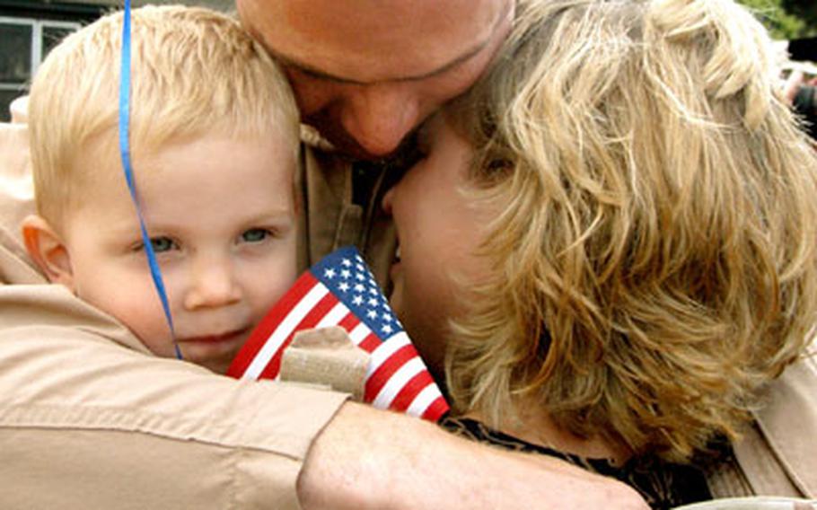 Sgt. Kerry Boese and wife Sheila share a tender moment as son Samuel, 22 months, just seems happy to have dad home. Boese and other members of the 159th Medical Company, 421st Medical Evacuation Battalion, returned to Wiesbaden, Germany, from Operation Iraqi Freedom on Wednesday.