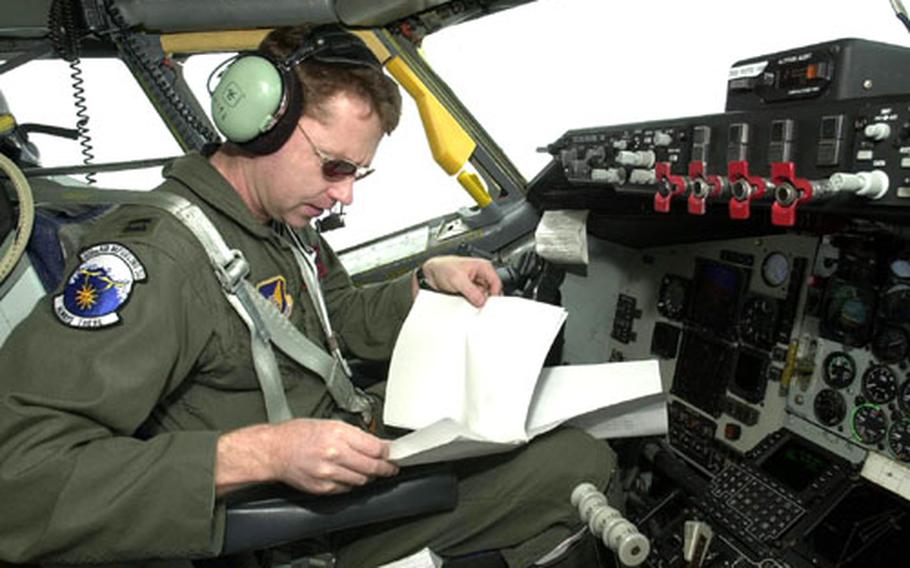 Capt. Rusty Evers checks over paperwork while his KC-135R tanker flies on autopilot 21,000 feet over the Sea of Japan Tuesday. He was flying an air refueling mission for American and Japanese fighter aircraft flying in the Cope North exercise.