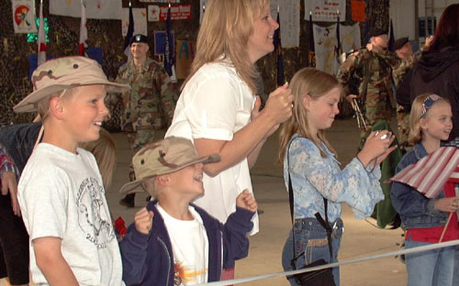 Michelle Beatty and her children, from left to right, Cameron, Jacob and Courtney, cheer at the sight of the soldiers entering the hangar at Storck Barracks in Illesheim, Germany, on Wednesday.