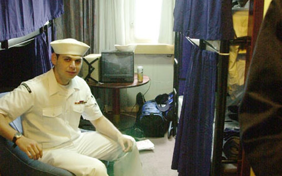 Petty Officer 3rd Class Israel Lopez takes a break in his new room on board the berthing barge Olympia.