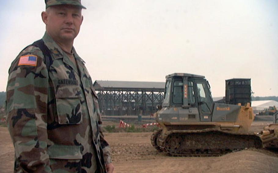 Maj. Bill Gatewood watches as a bulldozer smooths out a field that will soon be covered in mountains of sewage sludge. Gatewood, a reservist who is a farmer in civilian life, is using composting techniques to rid Camp Bondsteel of waste that would otherwise have to be incinerated at a much higher cost.