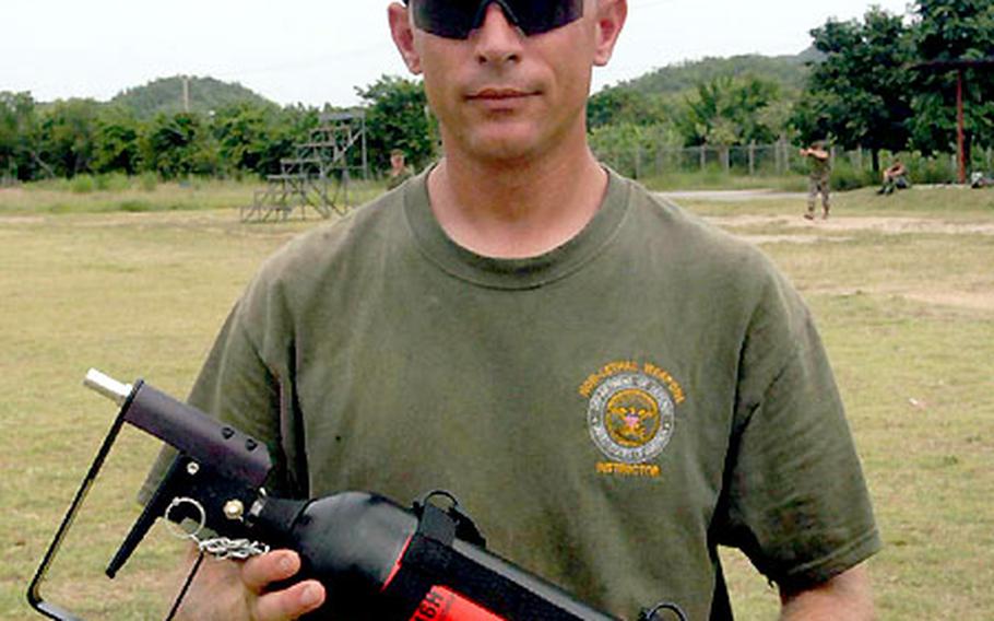 Non-lethal weapons trainer Gunnery Sgt. Kenneth Kurre shows a canister of pepper spray used for crowd control.