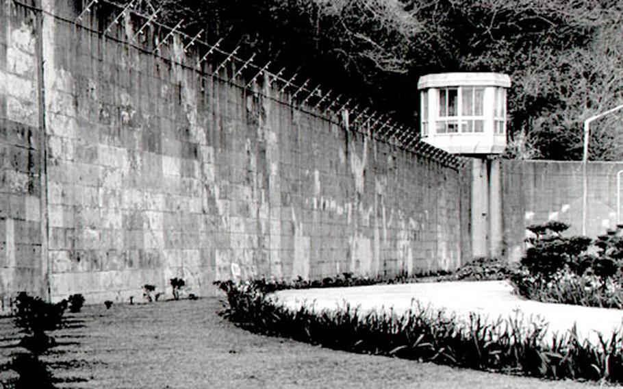 A large wall topped with barbed wire surrounds the prison in Yokosuka, Japan. The 18 U.S. servicemembers at the prison, and other qualified foreign prisoners, can petition to serve the remainder of their sentences in prisons in their home countries.
