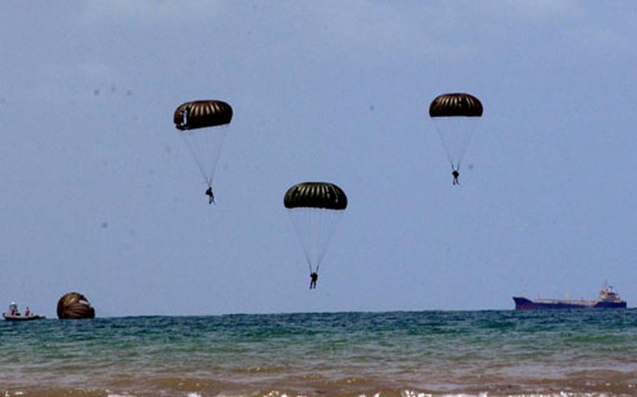 U.S. and Royal Thai Navy explosive ordnance disposal team members parachute Wednesday from a C-130 plane into the sea off Thailand during a combined U.S.-Thai training jump during Cobra Gold.