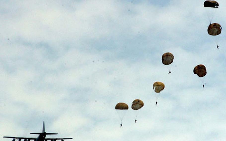 U.S. and Royal Thai Navy explosive ordnance disposal team members parachute Wednesday from a C-130 plane into the sea off Thailand during a combined U.S.-Thai training jump during Cobra Gold.