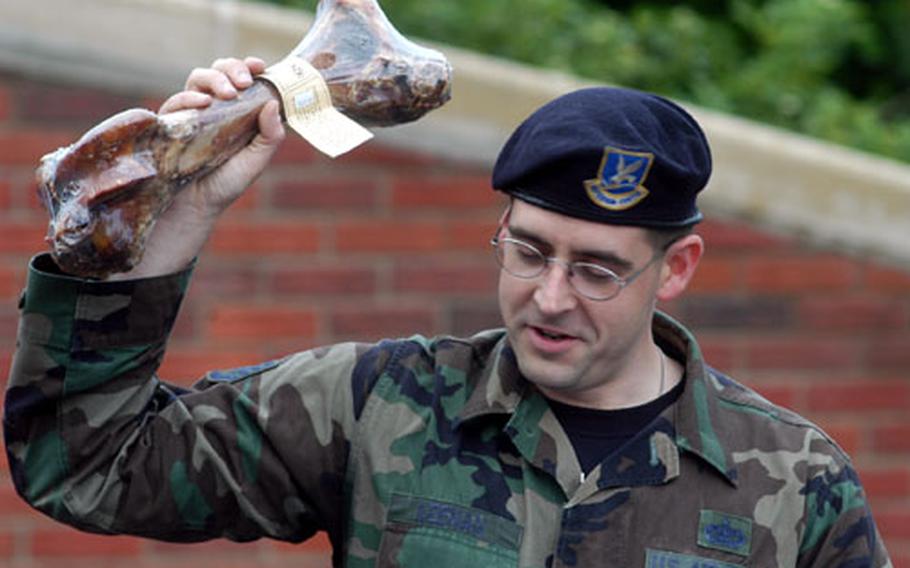 Staff Sgt. Edward Keenan holds aloft a bone given to Harras, a military working dog, who was retired from service in a ceremony Friday at RAF Lakenheath, England. Keenan, a member of the 48th Security Forces Squadaron, was master of ceremonies for the event.