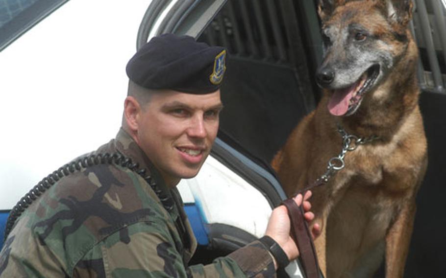 Staff Sgt. Jeffrey Crawn and Harras, a military working dog, prepare Friday for a retirement ceremony for Harras. The dog ended 12 years of service to the U.S. Air Force.