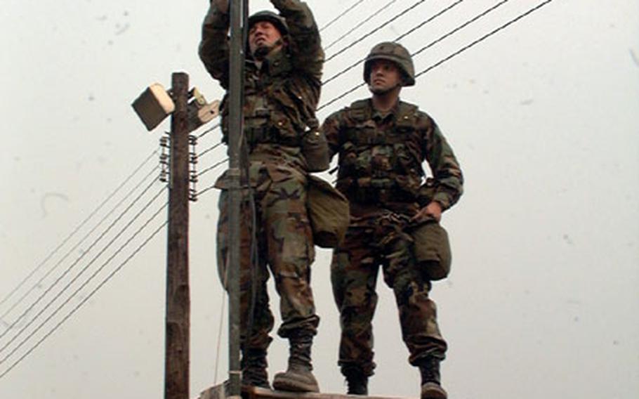 Members of Army communications unit in South Korea work on cable during unit training exercise at Army&#39;s Camp Walker in Taegu. Pfc. Jonathan Glover (left) and Spc. Dennis McVey (right) are members of Company B, 307th Signal Battalion, out of Camp Carroll in Waegwan.