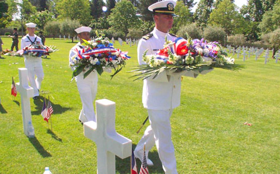 Navy Lt. Corey Barker leads a pair of sailors carrying wreaths during a Memorial Day ceremony Sunday at the Rhone American Cemetery in Draguignan, France.