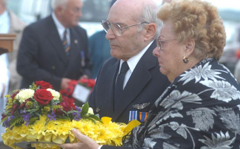 Bill Lyons, president of the 355th Fighter Group Association, and Theresa Angileri, sister of a pilot who died while with the unit in World War II, prepare to lay a wreath during a service Saturday at the unit&#39;s wartiime base in Steeple Morden, England.