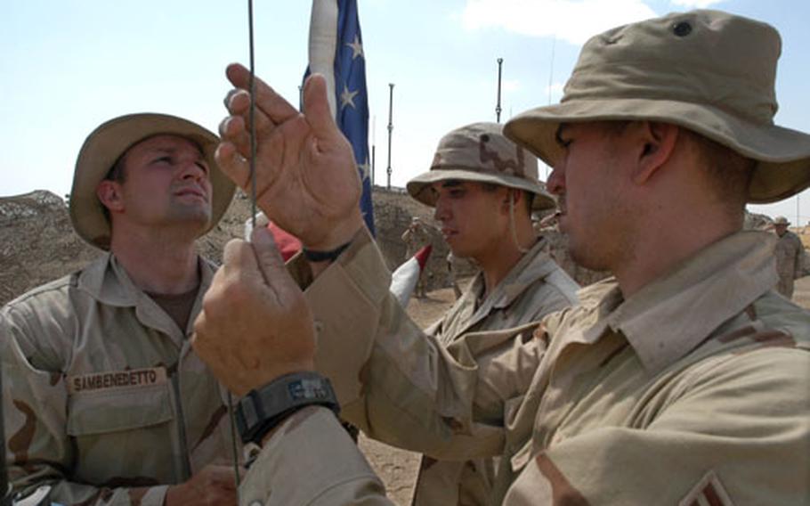 Tech. Sgt. Sam Sanbendetto, left, Staff Sgt. Thomas Ray and Airman 1st Class Anthony Hebert raise the American flag over the 606th Air Control Squadron&#39;s compound at Kirkuk airfield Sunday. The three set up the flag pole and then raised the flag that belongs to Sanbendetto.