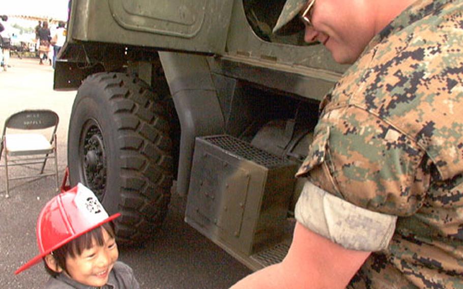 Lance Cpl. Willie Shaffer, a motor transportation operator at Camp Fuji, Japan, shakes the hand of Kousei Kusaba, after showing him the inside of a 5-ton tactical truck.