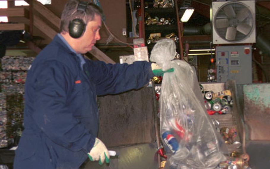 A worker at the Endurvinnslan Recycling Plant in Reykjavík prepares to unload a bag of aluminum cans into one of the plant&#39;s compacting machines. The cans then travel up a conveyor belt where they are fed into a part of the machine that will crush and compact them, making them ready for shipment.
