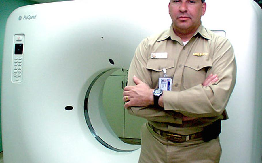 Navy Cmdr. Brian Lewis, division officer for the USNS Comfort&#39;s casualty receiving department, stands in front of the ship&#39;s CT scanner. Lewis said the scanner was critical for doctors and nurses treating casualties from the war in Iraq, and operated almost around the clock at the height of the conflict.