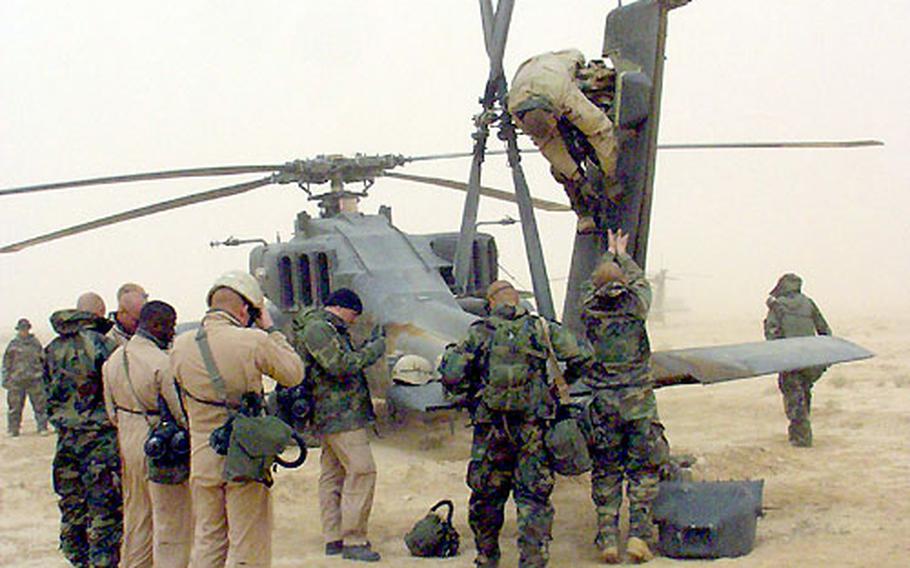 Mechanics from the 1st Battalion, 227th Aviation Regiment work on the tail of an AH-64D Longbow damaged in Task Force 11th Aviation’s attack on the Medina Division.
