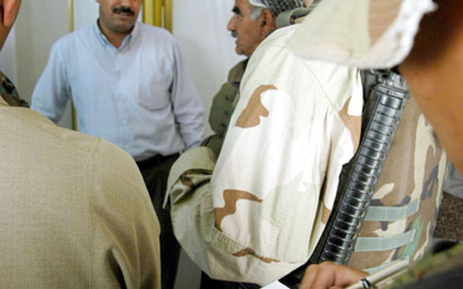 Capt. Earl Avecilla, right, of the 404th Civil Affairs Battalion out of Fort Dix, N.J., takes notes as Maj. Christopher Schrieks questions the physician&#39;s assistant at the Garawe, Iraq, medical center about the village&#39;s medical situation.