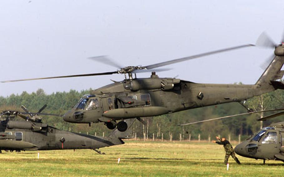 A crew chief signals a Black Hawk helicopter from V Corps&#39; C Company, 5th Battalion, 158th Aviation Regiment, 12th Aviation Brigade, for take off from Miroslawiec Air Base, Poland, at the start of a combat search-and-rescue exercise during Victory Strike III. Training at bases, such as the one in Poland, is less restrictive than at the Army&#39;s two main training centers in Germany — Grafenwöhr and Hohenfels.