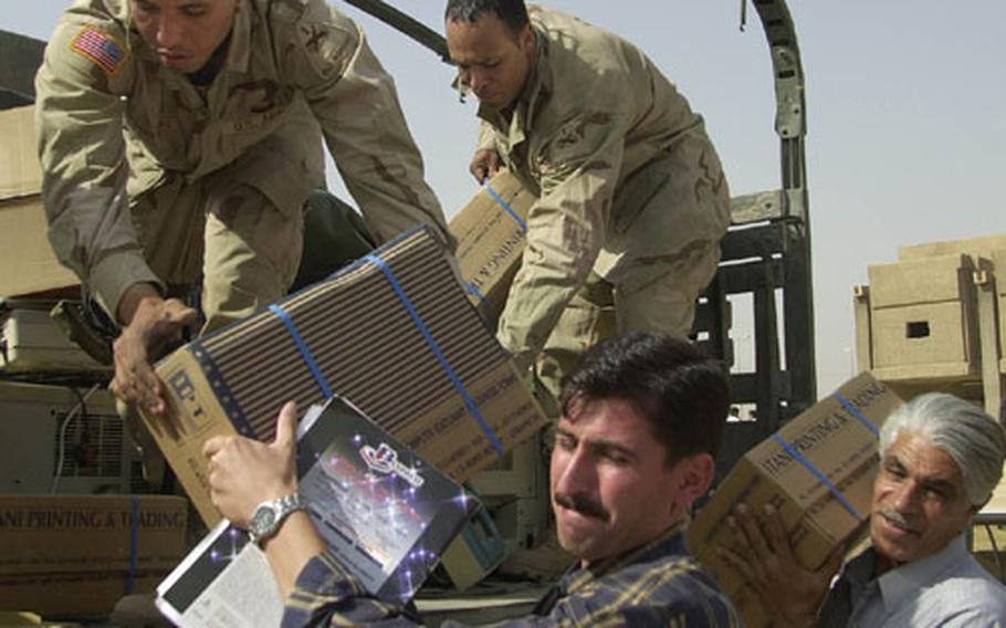 Students and faculty of Baghdad University&#39;s College of Pharmacy carry away boxes of supplies being unloaded by Sgt. Ramon Blanco, left, and Spc. Joseph Carter, both of the 16th Engineer Battalion. The battalion delivered three truck loads of computer equipment and supplies to the college on Sunday.