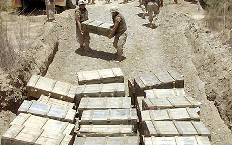 The soldiers of the 41st Field Artillery Brigade unload Iraqi munitions at Red Rocket, a quarry northwest of Baghdad. The muntions are kept there until they are destroyed.