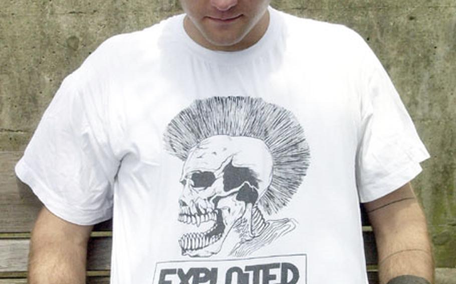 USS Essex sailor Petty Officer 3rd Class Aaron Sanders shows the black and white drawing on his T-shirt at Sasebo Naval Base, Japan. Some T-shirts with offensive language and symbols are prohibited by the Navy civilian attire regulations.