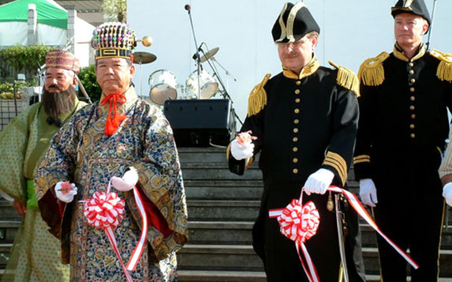 Naha Mayor Takeshi Onaga, front left, and U.S. Consulate General Timothy Betts, front right, cut the ribbon Sunday to start the "American Fest in Tomari," celebrating the 150th anniversary of the arrival of U.S. Commodore Matthew Perry&#39;s fleet in Naha harbor on its way to open Japan to foreign trade. Betts is dressed as Perry and Mayor Onaga is dressed as the King of the Ryukyus.