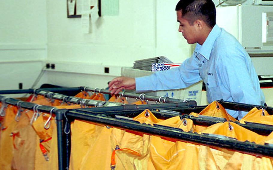 Seaman Alfredo Garcia begins sorting out the mail collected earlier that morning.