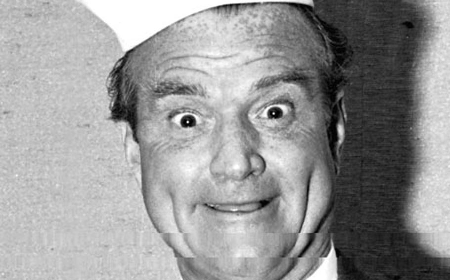 During a Stars and Stripes interview session, Red Skelton tries on one hat ...