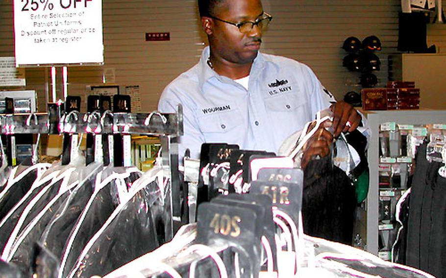 Chief Petty Officer (Select) Carlton Wourman takes a closer look at a chief petty officer jacket at Yokosuka’s uniform shop Tuesday. Wourman, an intelligence specialist on USS Curtis Wilbur, found out Tuesday he had been selected for promotion to chief petty officer.