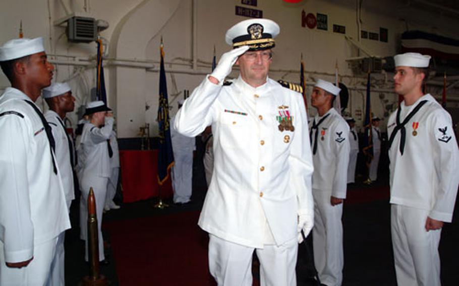 Capt. Jan M. van Tol passes through the traditional sideboys during the recent change of command ceremony for the USS Essex held in the ship&#39;s hangar bay. Capt. van Tol relieved Captain Ronald R. Evans as skipper during the ceremony attended by about 200 sailors and guests.