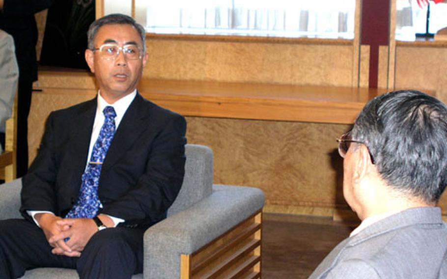 Shoei Yamanaka, director general of the Defense Facilities Administration Agency, left, meets with Okinawa Gov. Keiichi Inamine Friday. An explosion last week "shattered the trust that people of Okinawa have held toward the Self-Defense Force," Inamine said.