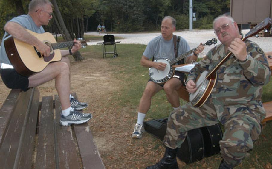 Chief Warrant Officer 4 Don Case, left, Chief Warrant Officer 4 Joe Dayringer, and Chief Warrant Officer 4 Finice Matthews, play banjos and guitar at a park on Eagle Base, Bosnia and Herzegovina. They are one of several groups on base whose favorite pastime during the six-month deployment nearing its end was playing music.