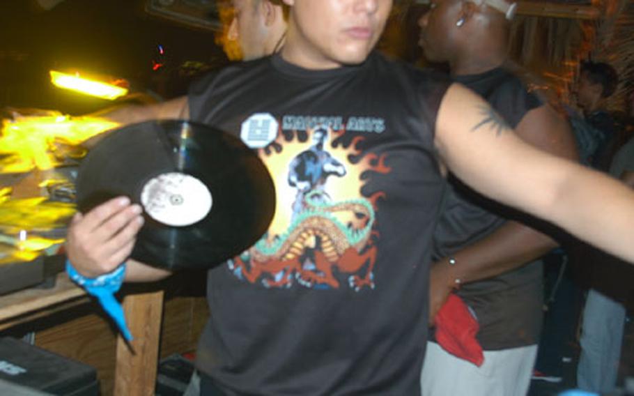 Petty Officer 2nd Class Shane Baker gets ready to spin records at a club in Salerno, Italy.