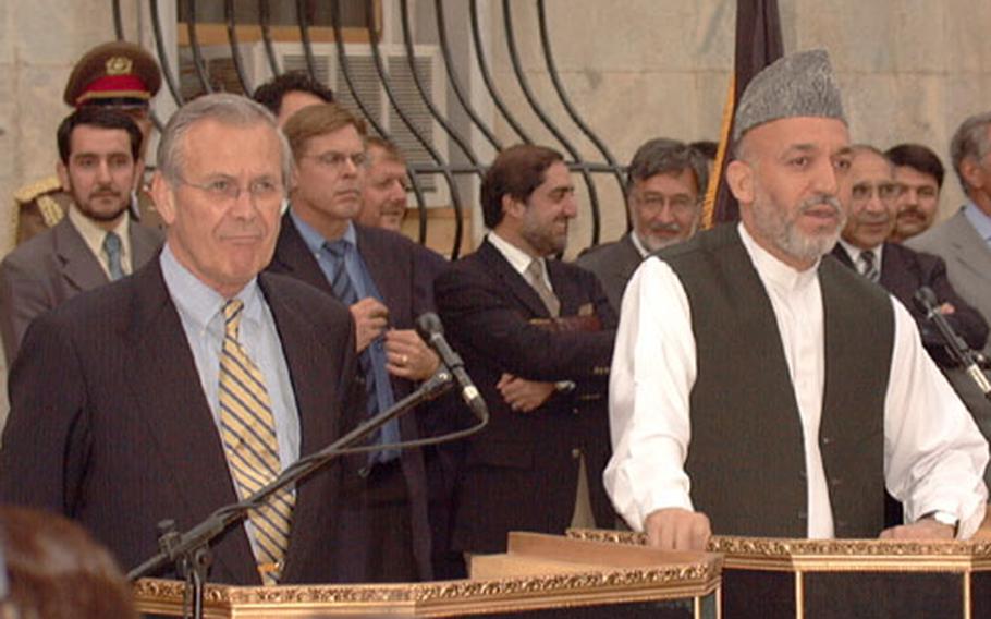 Secretary of Defense Donald Rumsfeld, left, and Afghanistan President Hamid Karzai hold a joint press conference Friday at the presidential palace in Kabul. Rumsfeld and Karzai met to discuss a variety of subjects including reconstruction and the recent firefighting near the border of Afghanistan/Pakistan border.